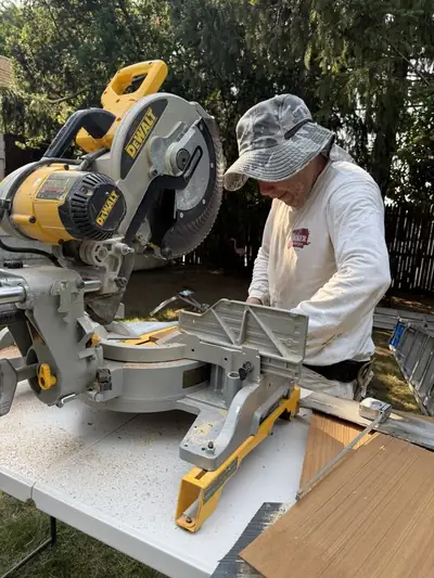 Close-up of a crew member making a precise cut on the miter saw